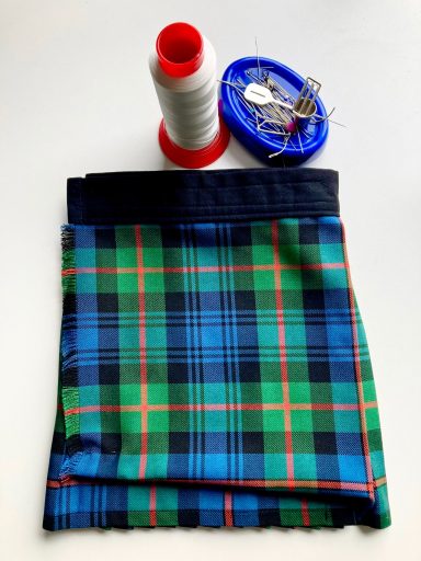 finished bespoke baby kilt with sewing tools